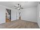 Comfortable bedroom with plush carpeting, a ceiling fan, and an en-suite bathroom and closet at 18369 W La Senda Dr, Surprise, AZ 85387