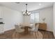 Cozy dining room features a round table, chandelier, and natural light from the window at 18369 W La Senda Dr, Surprise, AZ 85387