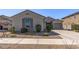 Well-maintained home showcases desert landscaping, a three-car garage, and a charming exterior at 18369 W La Senda Dr, Surprise, AZ 85387