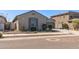 Exterior view of a charming home with desert landscaping, concrete sidewalk and driveway at 18369 W La Senda Dr, Surprise, AZ 85387