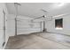 Spacious two-car garage featuring a concrete floor, overhead lighting, and automatic door opener at 18369 W La Senda Dr, Surprise, AZ 85387