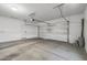 Well-lit two-car garage showing concrete floors, a door to the house, and an automatic door opener at 18369 W La Senda Dr, Surprise, AZ 85387