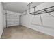 Two-car garage showcasing concrete floor and overhead storage rack at 18369 W La Senda Dr, Surprise, AZ 85387