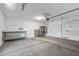 Bright two-car garage with a concrete floor, ample lighting, and includes installed shelving for storage at 18369 W La Senda Dr, Surprise, AZ 85387
