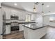 Modern kitchen boasts white cabinets, granite countertops, stainless steel appliances, and a spacious center island at 18369 W La Senda Dr, Surprise, AZ 85387