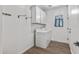 Well-lit laundry room featuring white cabinets, washer, dryer, and tile floors at 18369 W La Senda Dr, Surprise, AZ 85387