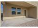 Covered back patio with concrete floor, providing a relaxing outdoor space with neutral stucco walls at 19437 W Elm St, Litchfield Park, AZ 85340