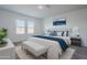 Serene primary bedroom with plush bedding, bench, soft carpet, and natural light at 19437 W Elm St, Litchfield Park, AZ 85340