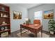 Comfortable home office featuring natural light, desk, office chair, and shelving at 19437 W Elm St, Litchfield Park, AZ 85340