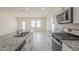 Bright kitchen with white cabinets, stainless steel appliances, and a spacious layout overlooking the living area at 19437 W Elm St, Litchfield Park, AZ 85340