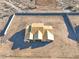 An overhead aerial shot reveals the unique roofline of a new home under construction within its expansive fenced lot at 20255 W Highland Ave, Litchfield Park, AZ 85340