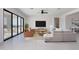 A bright, open living room features contemporary furnishings, a large screen television, and sliding glass doors to outside at 20256 W Highland Ave, Litchfield Park, AZ 85340