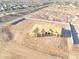 Aerial view of a home under construction with desert landscaping, framed by a block fence, with city views at 20274 W Highland Ave, Litchfield Park, AZ 85340