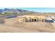 Home under construction featuring a distinctive roofline, framed windows, and set against a backdrop of desert scenery at 20274 W Highland Ave, Litchfield Park, AZ 85340