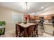 Open kitchen and eating area features tile floor, wooden cabinets, and a kitchen island at 2110 S 102Nd Ln, Tolleson, AZ 85353