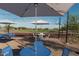 View from under umbrella of community basketball court and picnic area with tables, umbrellas, and string lights at 2232 W Chisum Trl, Phoenix, AZ 85085
