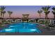 Community pool at dusk surrounded by palm trees, lounge chairs, and cabanas at 2232 W Chisum Trl, Phoenix, AZ 85085