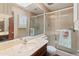 A bathroom features a large mirror, a vanity with sink, and glass shower doors at 2349 W Shaw Butte Dr, Phoenix, AZ 85029