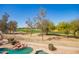 Backyard area with golf course view, pool, and desert landscaping in a fenced yard at 2602 E Glass Ln, Phoenix, AZ 85042