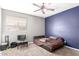 Comfortable bedroom featuring carpet, blue accent wall, ceiling fan, plus a black chair and desk at 2602 E Glass Ln, Phoenix, AZ 85042