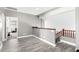 Hallway with wood-look flooring that leads to carpeted rooms and a wooden staircase at 2602 E Glass Ln, Phoenix, AZ 85042