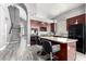 Modern kitchen with granite countertops, sleek appliances, and an island with bar seating and luxury vinyl plank flooring at 2602 E Glass Ln, Phoenix, AZ 85042