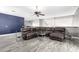 Open living room features a large brown leather sofa with a ceiling fan and wood-look flooring at 2602 E Glass Ln, Phoenix, AZ 85042