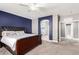 Main bedroom features a king bed, carpet, blue accent wall and archway to bathroom at 2602 E Glass Ln, Phoenix, AZ 85042