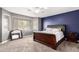 Main bedroom features a king bed, carpet, blue accent wall, and large windows with natural light at 2602 E Glass Ln, Phoenix, AZ 85042