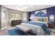 Stylish main bedroom with a blue accent wall, plush carpeting, and abundant natural light at 2602 E Glass Ln, Phoenix, AZ 85042