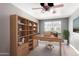 Home office with custom shelving, built-in desk, and a window overlooking the yard at 2602 E Glass Ln, Phoenix, AZ 85042