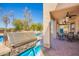 Outdoor kitchen with a built-in grill and covered patio with a table and chairs at 2602 E Glass Ln, Phoenix, AZ 85042