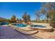 Beautiful pool and spa with rock features, surrounded by desert landscaping at 2602 E Glass Ln, Phoenix, AZ 85042