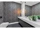 Stylish bathroom with modern vessel sink, pendant lights, textured wall and sleek fixtures at 26885 N 87Th Dr, Peoria, AZ 85383