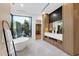 Modern bathroom with a soaking tub, large window, and a double vanity at 26885 N 87Th Dr, Peoria, AZ 85383
