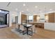 Open dining room with modern table, chairs, and a view of the spacious kitchen and backyard at 26885 N 87Th Dr, Peoria, AZ 85383