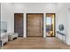 Bright foyer with light hardwood floors, modern furniture, and a large pivot door at 26885 N 87Th Dr, Peoria, AZ 85383
