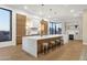 Modern kitchen with a large island, light wood cabinets, and stunning sunset views at 26885 N 87Th Dr, Peoria, AZ 85383