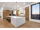 Modern kitchen featuring a large island, pendant lighting, and wood-paneled cabinets at 26885 N 87Th Dr, Peoria, AZ 85383
