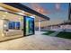 A covered patio with travertine flooring and outdoor kitchen flows seamlessly from the living space via sliding glass doors at 26885 N 87Th Dr, Peoria, AZ 85383