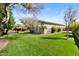 Sprawling backyard featuring lush green grass, mature trees, and a sparkling swimming pool at 27016 N 20Th Ln, Phoenix, AZ 85085