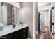 Bathroom featuring single sink vanity with wood floors, a large mirror and natural toned walls at 27016 N 20Th Ln, Phoenix, AZ 85085