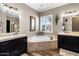 Inviting bathroom featuring a soaking tub, double vanities and wood-look floors at 27016 N 20Th Ln, Phoenix, AZ 85085