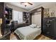 Cozy bedroom featuring built-in desk, shelving, shuttered windows and bed with decorative headboard at 27016 N 20Th Ln, Phoenix, AZ 85085