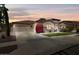 Beautiful home with a well-manicured yard, desert landscaping and attached two-car garage at dusk at 27016 N 20Th Ln, Phoenix, AZ 85085