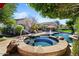 Backyard pool and hot tub with mature landscaping, poolside seating, and shade trees create a backyard retreat at 27016 N 20Th Ln, Phoenix, AZ 85085
