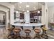 Open kitchen with granite counters, dark wood cabinets, a stainless fridge, and seating for five at the breakfast bar at 27016 N 20Th Ln, Phoenix, AZ 85085