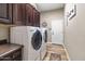 Laundry room featuring front-loading washer and dryer, dark cabinets and natural toned walls at 27016 N 20Th Ln, Phoenix, AZ 85085
