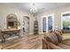 Spacious living room featuring wood floors, stylish decor, an elegant mirror, and french doors with iron detailing at 27016 N 20Th Ln, Phoenix, AZ 85085