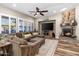 Open living room showcasing a fireplace, wood floors, plantation shutters, ceiling fan, and a large brown sectional couch at 27016 N 20Th Ln, Phoenix, AZ 85085